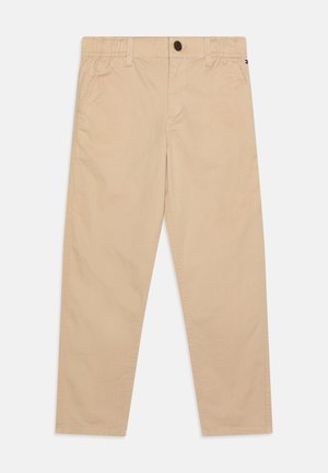 Pantaloni in cotone beige con una vestibilità rilassata, dotati di una cintura elastica, chiusura con bottone e tasche laterali. Texture liscia.