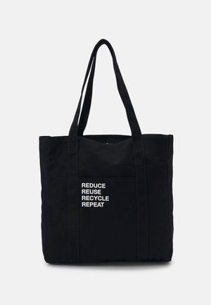 Svart totebag laget av stoff, med to hanker. Frontlommen viser teksten: "REDUSERE GJENBRUKE RESIRKULERE REPETER" i hvitt.