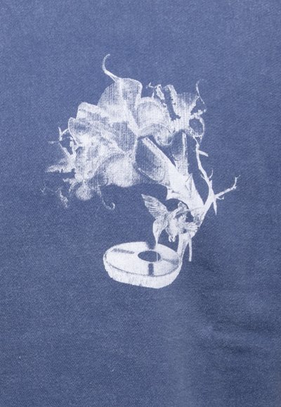Blue fabric featuring a white graphic design, depicting a vintage record player with floral elements and a small bird, detailed and textured.