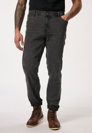 Grijze denim jeans met een rechte pasvorm, voorzakken en een opgerolde zoom, gecombineerd met bruine veterschoenen.