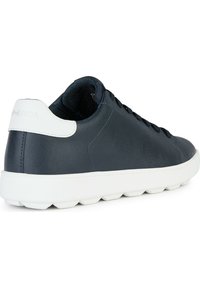 Sneaker in pelle blu navy con suola in gomma bianca, punta rotonda e interno testurizzato. Presenta lacci piatti e un accento sul tallone di colore contrastante.