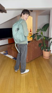 Σακίδιο Nike σε μέντα πράσινο χρώμα με λογότυπο, φτιαγμένο από ύφασμα, ορθογώνιο σχήμα, ρυθμιζόμενοι ιμάντες, συνδυασμένο με γκρίζα παντελόνια και λευκά παπούτσια.