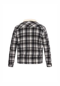 Vista trasera de una chaqueta de cuadros en negro, gris y blanco con mangas largas y un cuello de sherpa color crema.