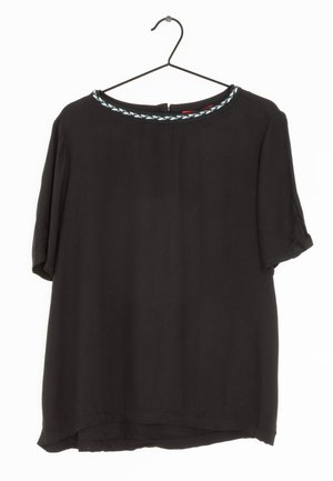 Sort kortærmet bluse med rund halsudskæring, der har en lyseblå flettet kant. Stoffet ser glat ud med en afslappet pasform og buet kant.