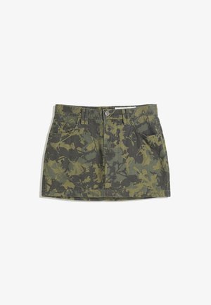Green camo denim skirt with a fitted waist, four pockets, and a button closure. Pattern includes dark and light green leaf designs.
