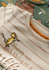 Trois chemises pour enfants : crème avec des rayures beige et une broderie de souris, marron avec un motif d'ours, verte avec des champignons. Tissu en coton doux.