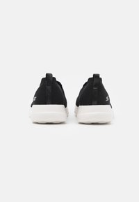 Schwarze Mesh-Sneaker mit weißen Gummisohlen, die über ein strukturiertes Obermaterial, Zugbänder an der Ferse und ein Logo an der Seite verfügen.