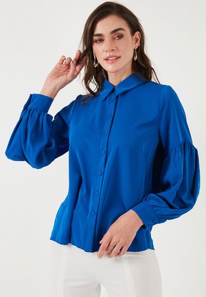 Blue button-up shirt with a collar, long puff sleeves, and smooth, shiny fabric. Features a tailored fit and slight flare at the hem.