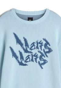 Maglione lavorato a maglia blu chiaro con un audace design grafico blu navy e testo astratto. Collo rotondo e polsini a costine. Texture morbida.