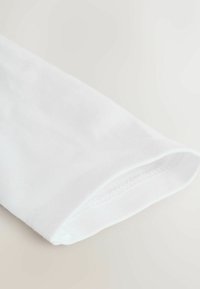 Manica in cotone bianco con una texture liscia, bordi cuciti in modo ordinato e una leggera curvatura all'apertura. Design minimalista, senza motivi.