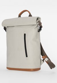 Zaino roll-top grigio chiaro con base in pelle marrone, dotato di tasca frontale con zip e spallacci regolabili. Texture liscia con un design minimalista.