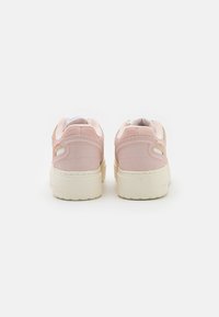 Rosa mockasneakers med rund form, vit innersida och beige gummisula. Sidoutskärningar och kontrasterande sömmar som detalj.