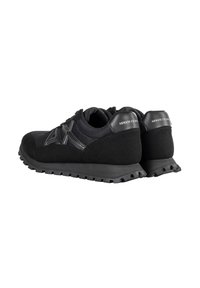 Paire de baskets noires Armani Exchange avec semelles texturées et logo au talon, vues de dos et de côté.
