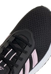 Schwarzer Sportschuh mit pinkfarbenen Akzenten, Mesh-Obermaterial, Schnürdesign und strukturierter Oberfläche. Mit drei weißen Streifen an der Seite.