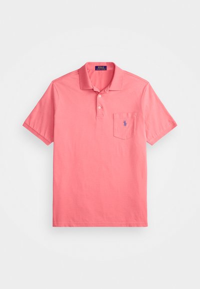 Roza polo majica iz bombaža, z dvema gumboma na ovratniku in žepom na prsih. Izvezena logotip v kontrastni modri barvi na žepu.