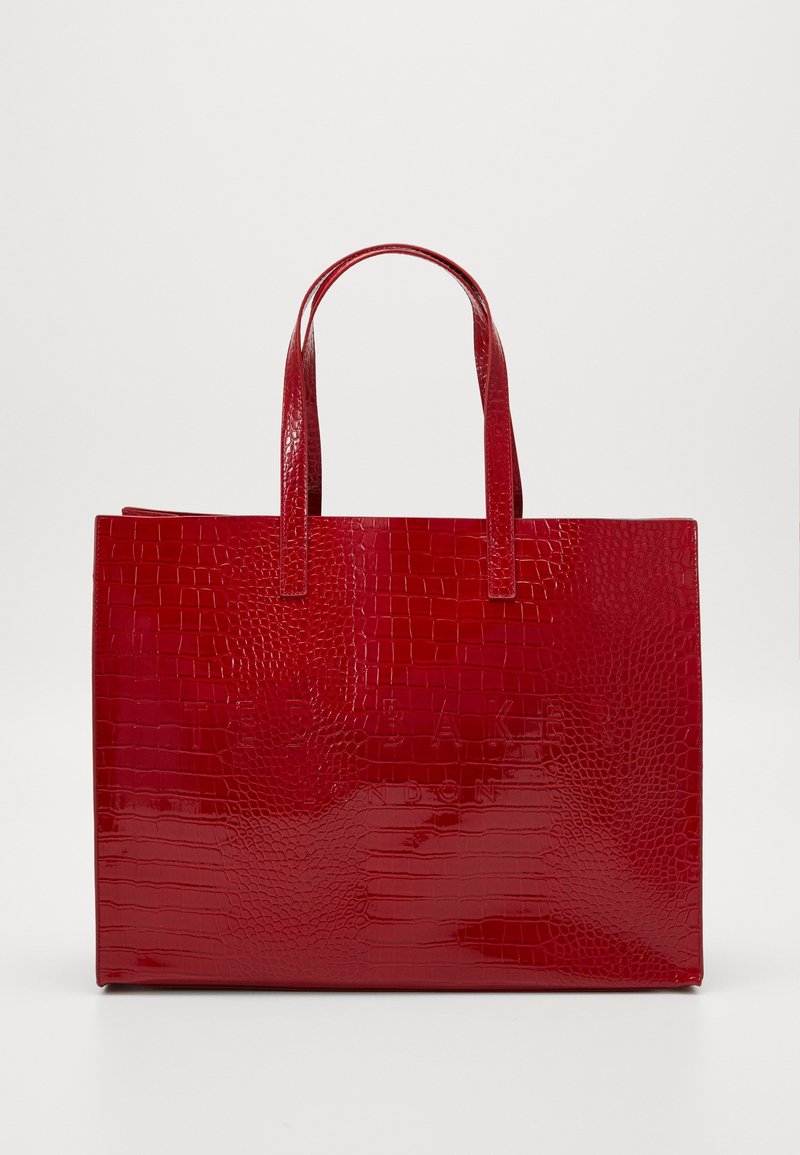 Sac cabas rouge brillant avec texture crocodile, deux poignées, forme rectangulaire et nom de marque embossé sur le devant.