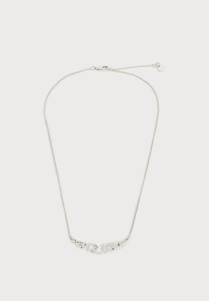 Collier chaîne en argent avec pendentif logo "Sacai" en écriture cursive et fermoir mousqueton sur fond blanc.