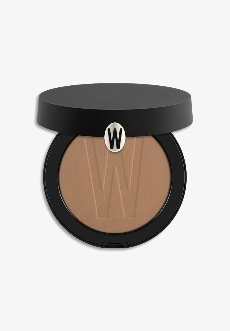 Polvere compatta pressata in un compact rotondo nero con una superficie beige liscia, con il logo "W" in rilievo sulla parte superiore. Coperchio nero con hardware argentato.