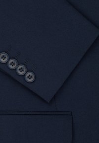 Materiał ciemnogranatowego garnituru o gładkiej fakturze, z pięcioma ciemnymi guzikami na mankiecie i kieszenią wszytą, prezentujący czyste linie i minimalistyczny design.
