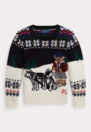 Zwart-witte wintersweater met sneeuwvlokpatronen, bomen en een teddybeer die een hoed, laarzen en een rood jasje draagt met twee huskydieren.