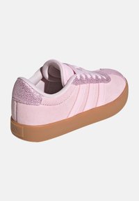 Pink suede sneaker with a textured pink accent at the heel, three stripes on the side, and a gum rubber outsole.
