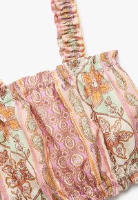 Bloemenprint top met gathered schouderbanden, in tinten van roze, oranje en groen. Gemaakt van lichtgewicht stof met ingewikkelde patronen.