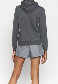 Szary hoodie o dopasowanym kroju, z teksturowanej tkaniny i kapturem. Zestawiony z jasnoszarymi spodniami szortami, o luźnym kroju i prostym przeszyciu.