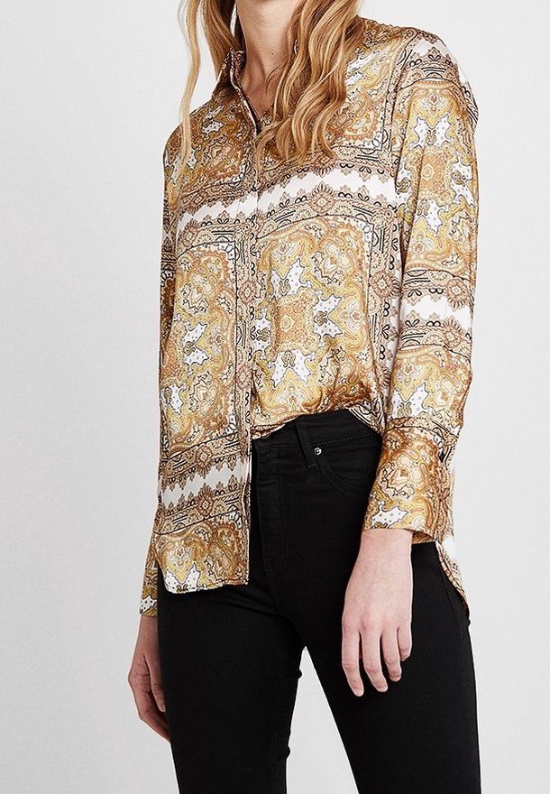 Långärmad skjorta i gyllene paisleymönster med vita och svarta accenter. Knappstängning framtill, krage och lätt böjd fåll. Mjuk tyg.