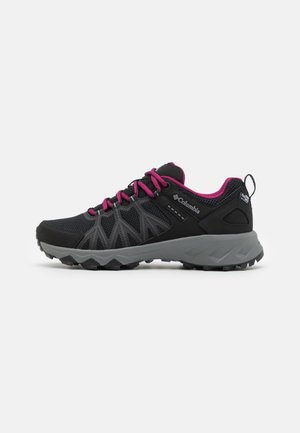 Zapatillas deportivas negras con detalles en rosa, parte superior de malla y sintético, suela de goma texturizada con tacos multidireccionales y talón reforzado.