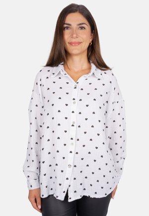 White button-up shirt with black heart patterns, made from lightweight fabric, featuring a collar and loose fit, with long sleeves.