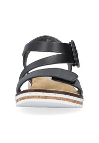 Black leather sandal featuring crisscross straps, adjustable buckle, cork footbed, and white rubber sole with a textured finish.