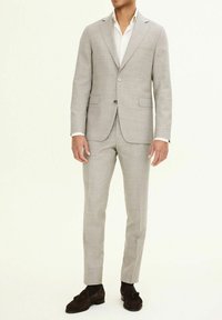 Completo grigio chiaro realizzato in tessuto testurizzato, con giacca a un bottone con revers a punta, due tasche frontali e pantaloni abbinati.
