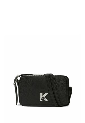 Sort tekstureret læder crossbody taske med sølv logo initialer, lynlåslukning og justerbar rem på hvid baggrund.