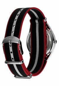 Zegarek Timex z czarnym nylonowym paskiem z czerwonymi i srebrnymi paskami, z metalową klamrą w kolorze srebrnym i stalowym tyłem.