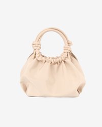 Beige textured handbag with a gathered top, dual knotted handles, and a rounded shape. Made from smooth synthetic material.