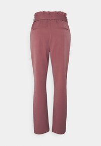 Pantalon taille haute mauve avec une ceinture assortie, taille paperbag et deux poches passepoilées à l'arrière, présenté de dos sur fond blanc.