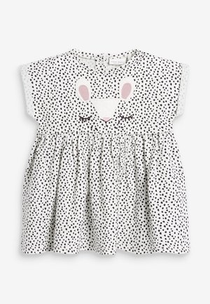 Hvid babykjole med sorte pletter, samlet skørt og broderet kaninansigt med lyserøde ører og lukkede øjne på brystet.