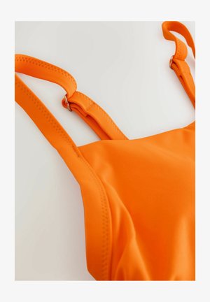 Ryškiai oranžinis maudymosi kostiumėlis su lygiu paviršiumi, reguliuojamomis petnešėlėmis ir siuvimo akcentais. Pasižymi paprastu, moderniu dizainu be raštų.