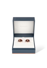 Runde Manschettenknöpfe in einem goldfarbigen Metallrahmen mit einem marmorierten Braun- und Cremelackeinlage, präsentiert in einer marineblauen Geschenkbox mit weißer Polsterung.