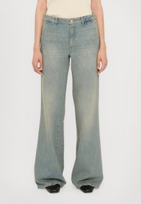 Jeans a gamba larga di colore blu chiaro realizzati in denim, con una finitura sbiadita, tasche frontali e chiusura con bottone in corrispondenza della vita.