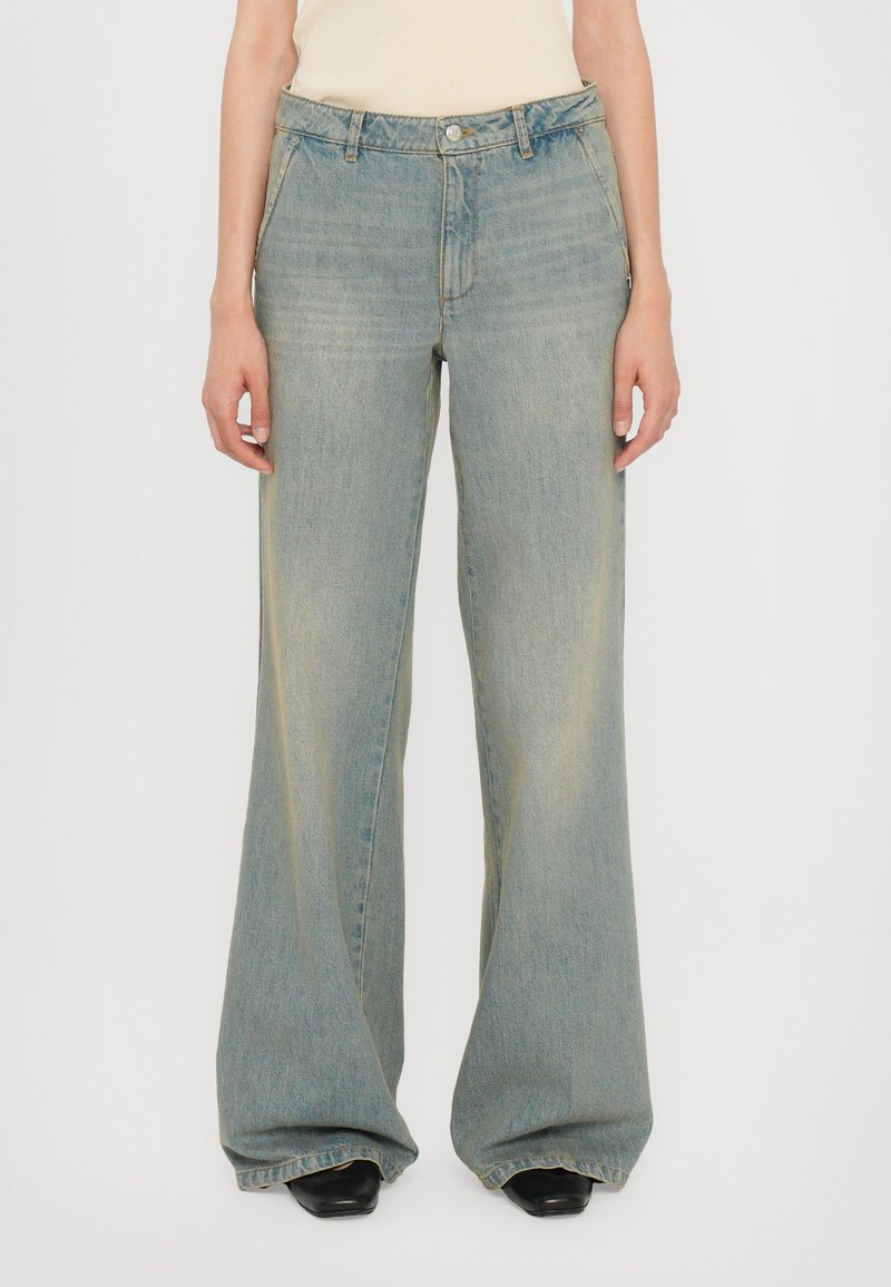 Jeans a gamba larga di colore blu chiaro realizzati in denim, con una finitura sbiadita, tasche frontali e chiusura con bottone in corrispondenza della vita.