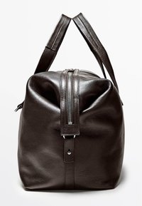 Dunkelbraune Leder-Reisetasche mit sichtbarem oberem Reißverschluss und zwei Griffen, aus seitlicher Perspektive auf weißem Hintergrund dargestellt.