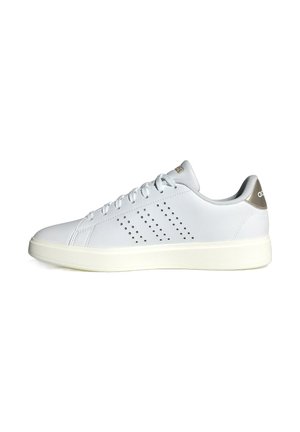 White athletic sneakers made of synthetic material with a smooth finish, featuring perforations on the sides and a light beige heel accent.