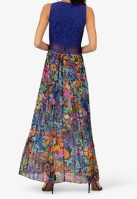 Lang bloemige jurk met een blauwe kanten corsage, met een levendige print van kleurrijke bloemen op een doorschijnende, geplooide rok.
