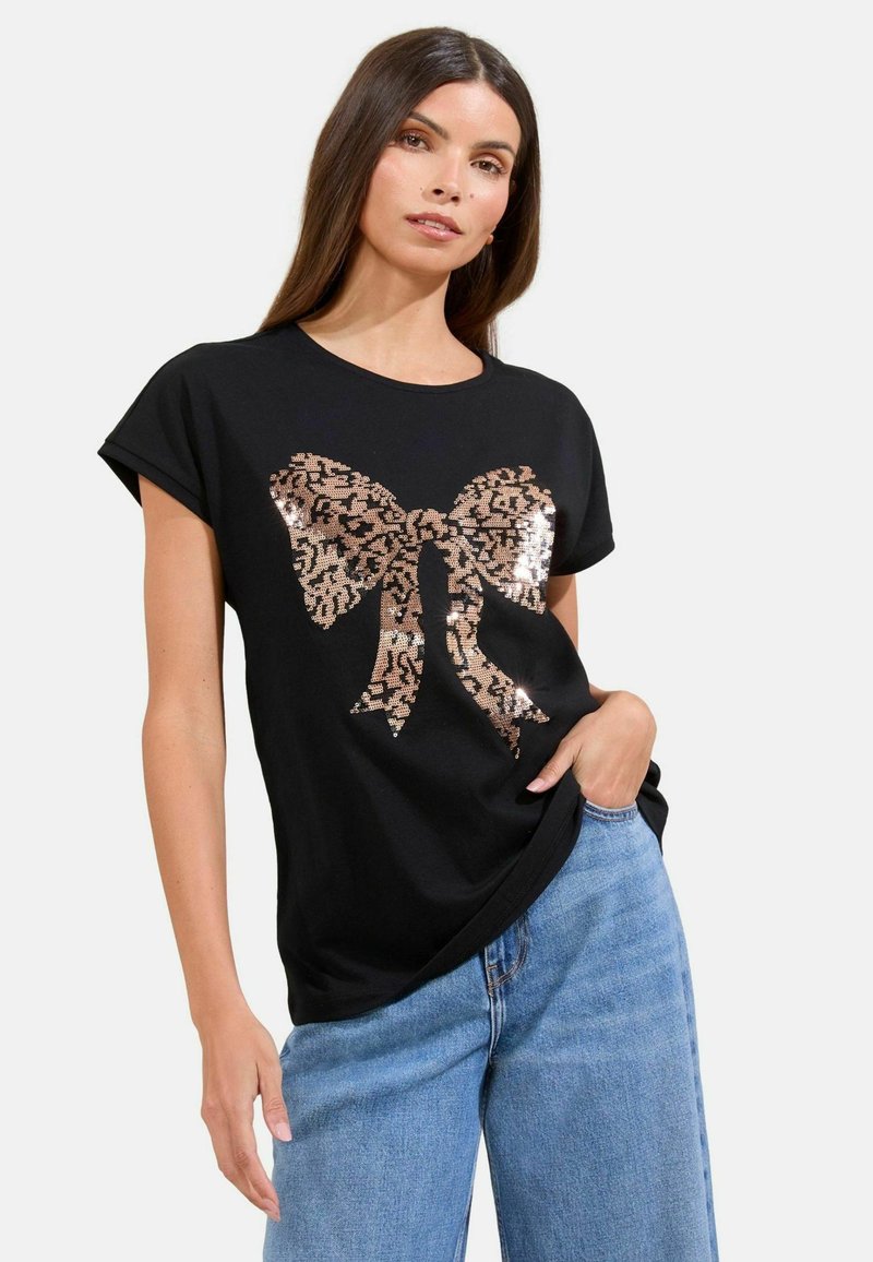 T-shirt nera a maniche corte con un grande fiocco in stampa leopardata di paillettes in tonalità di rosa oro sul davanti. Vestibilità casual.