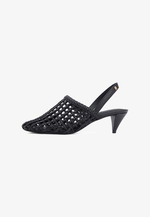 Sort slingback mule med flettet åbent gitterdesign og en lav, tilspidset hæl, med en lille guldemblem på remmen.