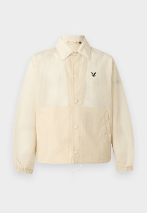 Μπεζ μπουφάν με κουμπιά, γιακά, ελαστικά μανίκια, πλαϊνές τσέπες, ρυθμιζόμενο κάτω μέρος με κορδόνι και μικρό μαύρο λογότυπο πουλιού στο αριστερό στήθος.