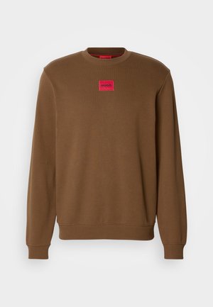 Brown crewneck sweatshirt with long sleeves and a red rectangular patch labeled "HUGO" centered on the chest.