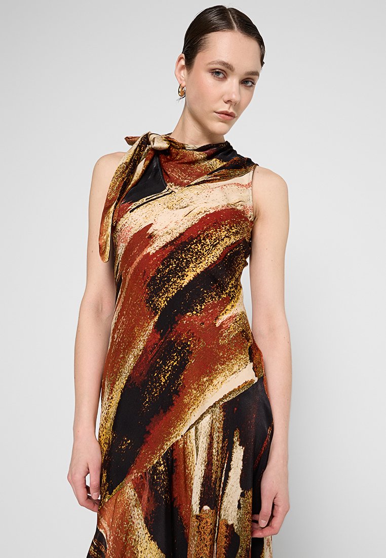 Vestido de satén con patrones abstractos en rojo, negro y dorado. Presenta un diseño sin mangas y un detalle de cuello atado. Textura suave.