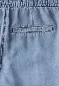 Jasnoniebieska tkanina o gładkiej fakturze, z prostokątną tylną kieszenią. Elastyczny pas zapewnia luźne dopasowanie.